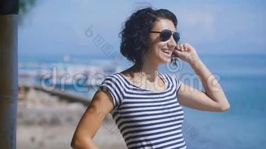 在夏天阳光明媚的日子里，一个美丽的黑发和蓝色海洋的短卷曲头发的特写。 青年